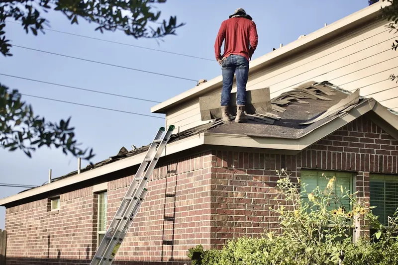 Professional roofer working on a residential roof in Brush Hill